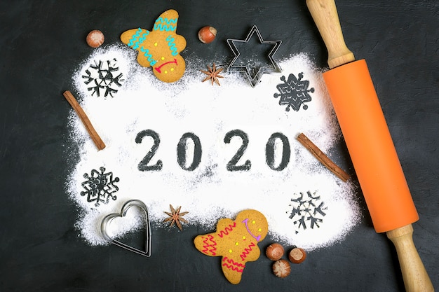 Texto de 2020 feito com farinha com decorações em preto. postura plana. Foto Premium