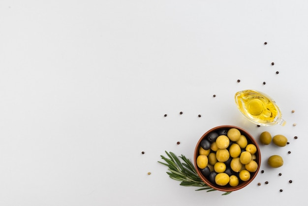 Tigela com azeitonas e copo com azeitonas de óleo na mesa Foto gratuita
