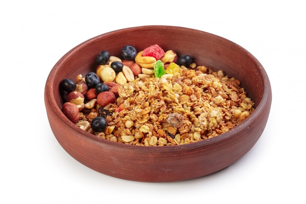 Tigela de granola caseira com pedaços de frutas isolado no branco Foto Premium