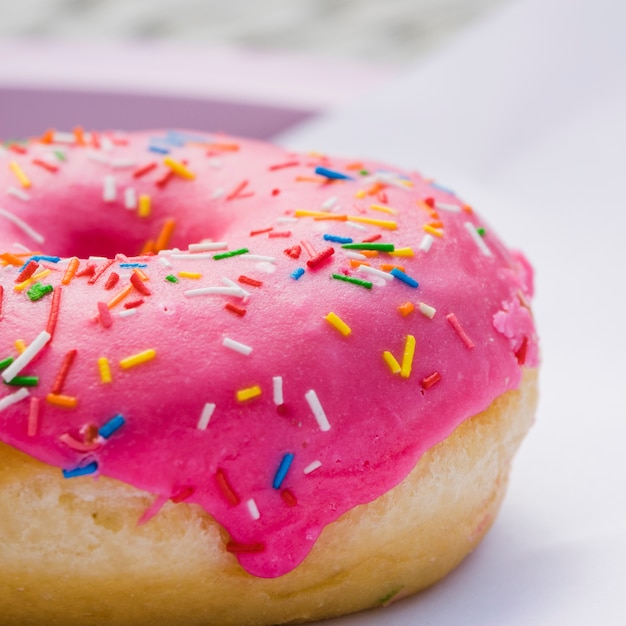 Tiro macro de donut com creme e colorido polvilha Foto gratuita