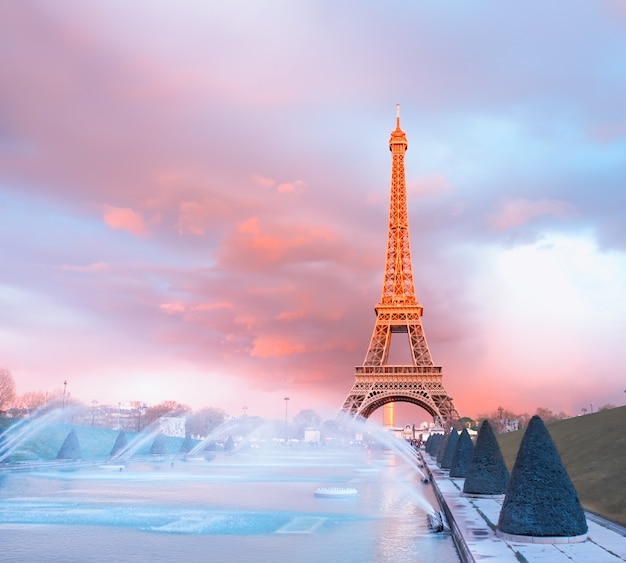 Torre eiffel em um pôr do sol semi-iluminado com os últimos raios do sol poente. Foto Premium
