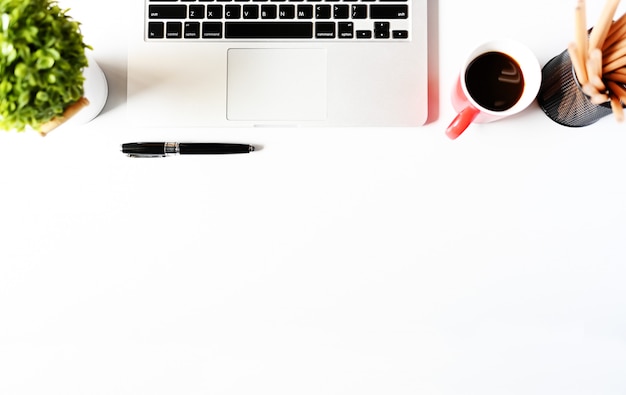 Trabalhando com computador portátil e planta e café cópia espaço no fundo da mesa moderna. estilo plano minmal espaço de trabalho, negócios conceito Foto Premium