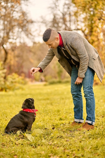 Treinamento canino um homem treinando seu cachorro no parque Foto Grátis