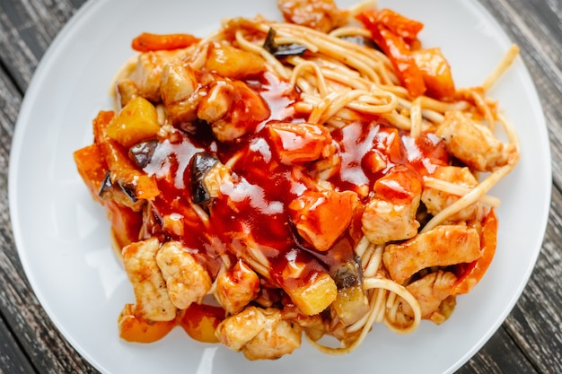 Udon frite o macarrão com frango e legumes em molho agridoce. cozinha asiática tradicional Foto Premium