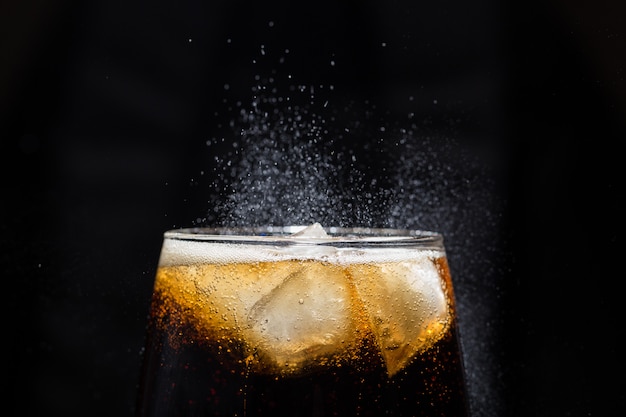 Um copo de bebida de cola com um close-up de sal. Foto Premium