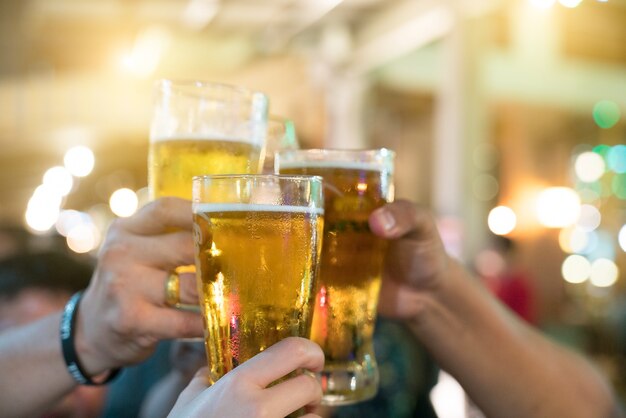 Um grupo de amigos com bebidas em uma boate. os jovens estão desfrutando Foto Premium