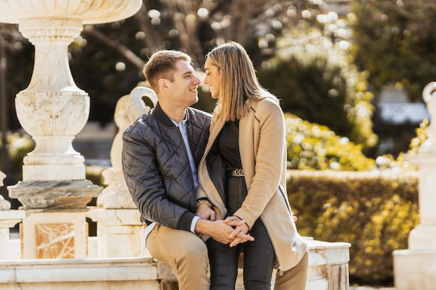 Um Homem Sentado Em Uma Fonte E Sua Namorada Entre As Pernas Sorrindo