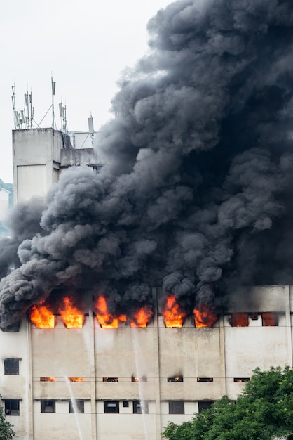 Um incêndio irrompeu no armazém e a brigada de incêndio apagava o fogo. Foto Premium