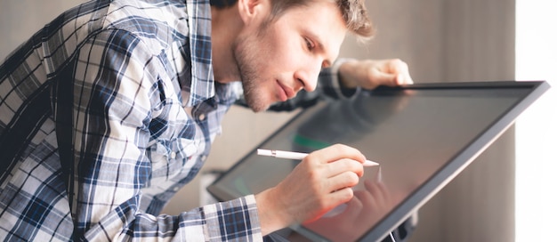 Um Jovem Artista Digital Masculino Desenhando Tinta Na Tela Do Computador Em Estudio Foto Premium