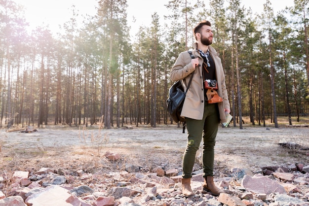 Um, macho, hiker, com, câmera, e, mochila, saco, ficar, em, a, floresta Foto gratuita