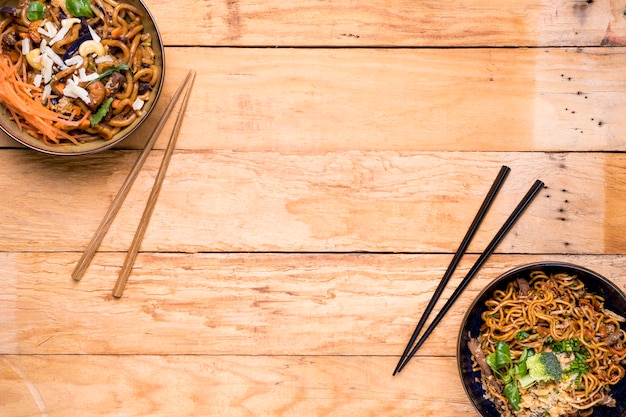 Um, visão aérea, de, noodles, bacias, com, chopsticks, ligado, prancha madeira Foto gratuita