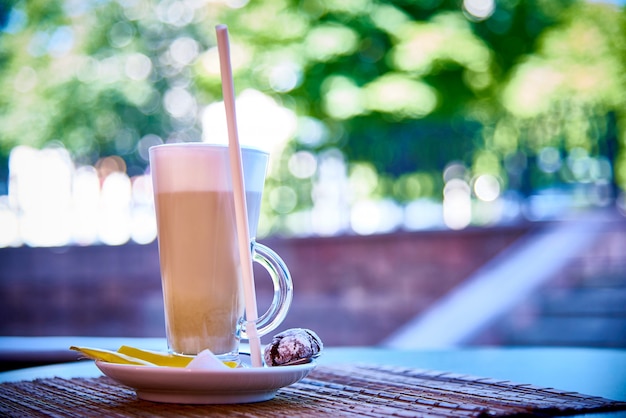 Uma bebida de café em um copo em um pires com biscoitos Foto Premium