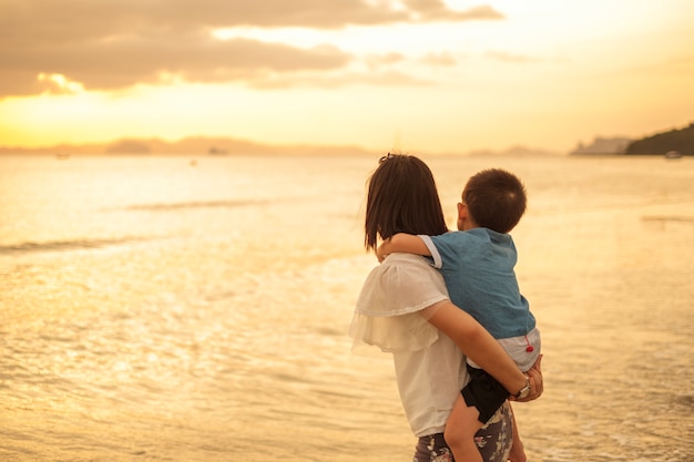 Uma mãe e filho ao ar livre ao pôr do sol com cópia espaço | Foto Grátis