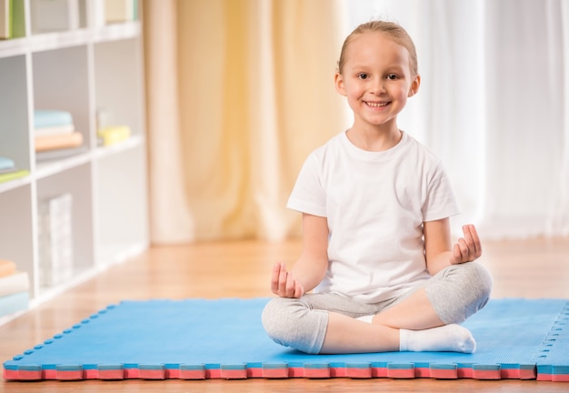 Uma menina sentada na esteira de exercícios. Foto Premium