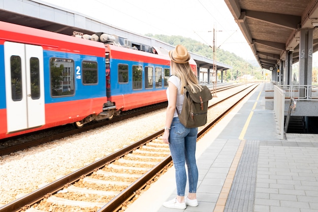 Viajante mulher em uma estação de trem Foto Grátis