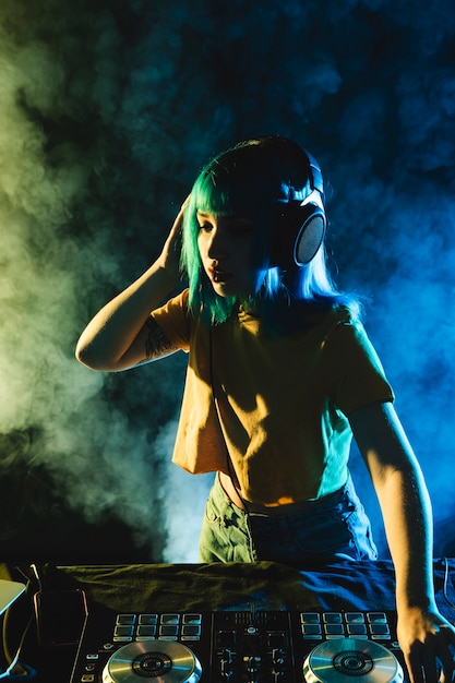 Vida noturna de alto ângulo com fumaça colorida e dj feminino Foto gratuita
