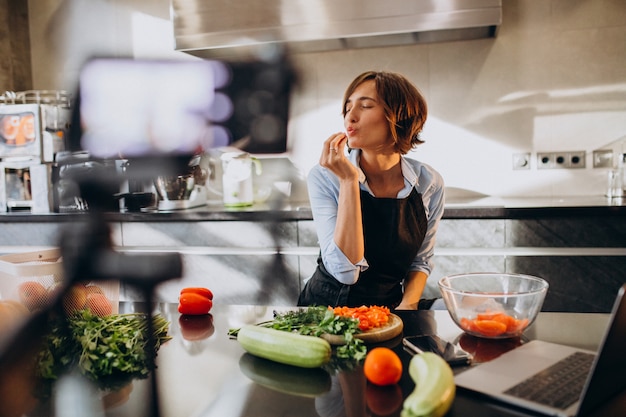 Videoblogger jovem cozinhar na cozinha e filmar | Foto Grátis