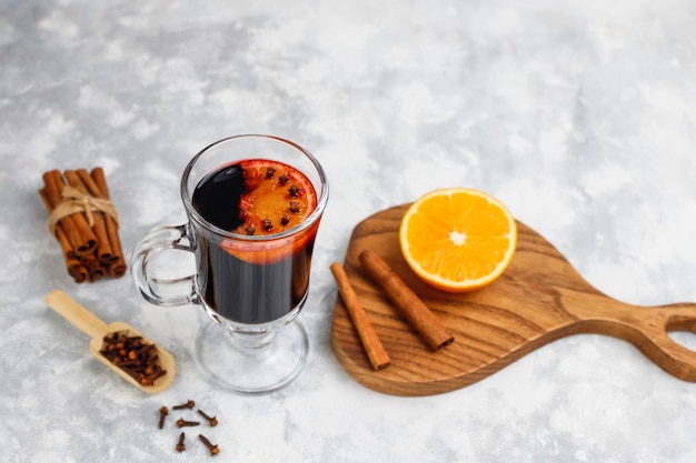 Vinho quente com glintwine servido em copos para mesa de natal com laranja e especiarias Foto gratuita