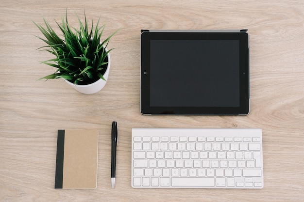 Vista de cima da mesa do escritório com teclado e tablet 