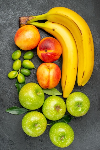 Vista de cima frutas na mesa frutas cítricas maçãs verdes com folhas de nectarina e banana