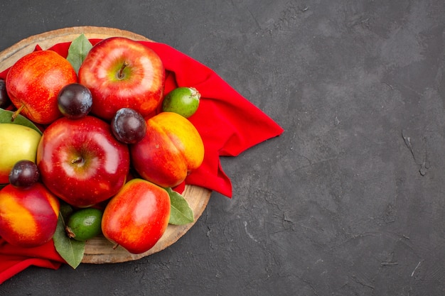 Vista de cima maçãs frescas com pêssegos e ameixas na mesa escura suco suave de árvore de fruta