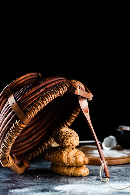Vista frontal de croissants e cesta na mesa Foto gratuita