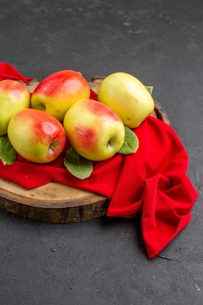 Vista frontal de maçãs frescas frutas maduras em tecido vermelho e mesa