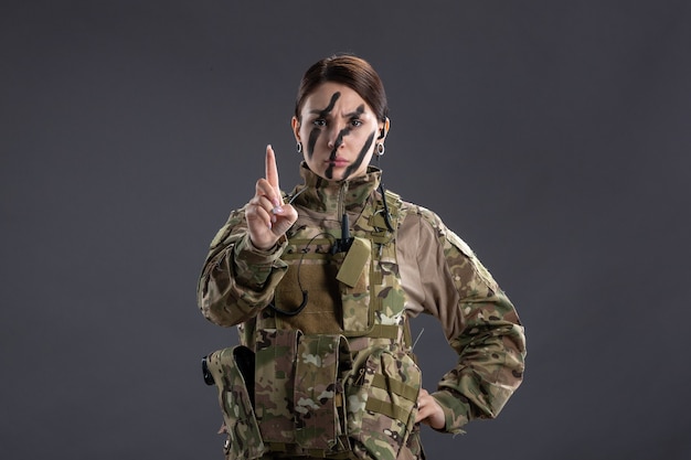 Vista Frontal De Uma Mulher Soldado Em Uniforme Militar Na Parede