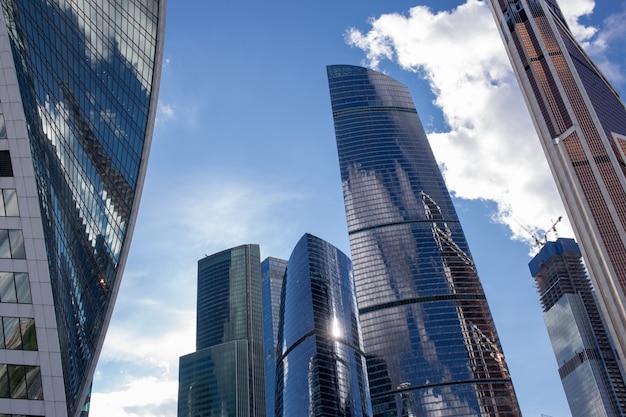 Vista inferior dos arranha-céus de moscou-cidade com design futurista, com reflexo das nuvens Foto Premium