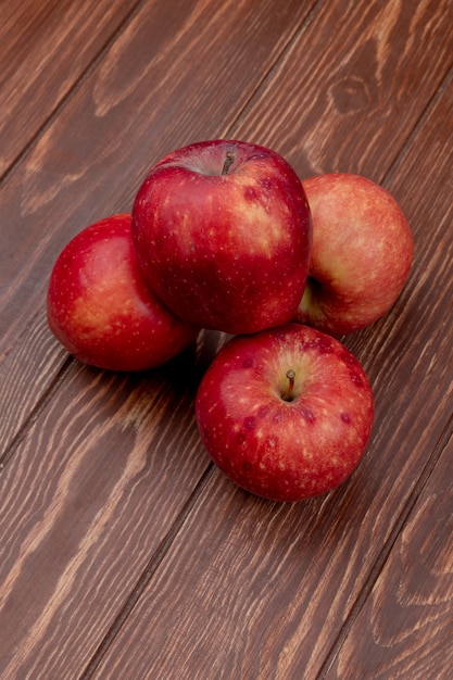 Vista lateral de maçãs vermelhas na superfície de madeira Foto Grátis