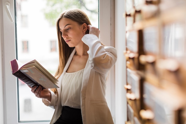Volta ao conceito de escola com mulher estudando na biblioteca Foto gratuita