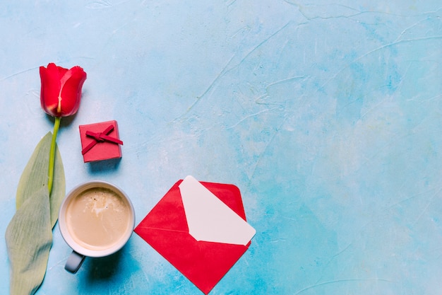Xícara de café com tulipa vermelha na mesa Foto gratuita