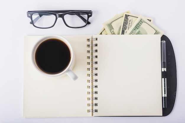 Xícara de café no notebook com óculos na mesa Foto gratuita