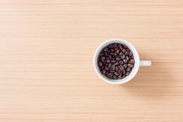 Xícara e grãos de café sobre fundo de madeira com espaço de cópia Foto Premium