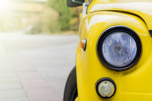 Abschluss oben des gelben retro- autos mit runden scheinwerfern. Premium Fotos