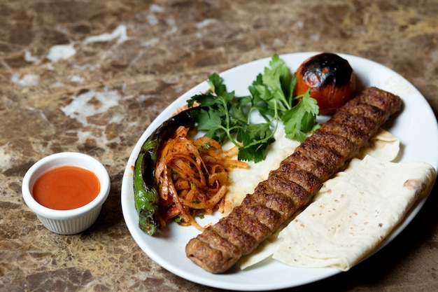 Adana Kebab Serviert Mit Fladenbrot Gegrilltem Pfeffer Und Tomaten Und Karamellisierten Zwiebeln Kostenlose Foto