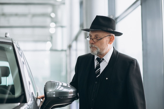 Alterer Mann In Einem Autosalon Der Ein Auto Wahlt Kostenlose Foto