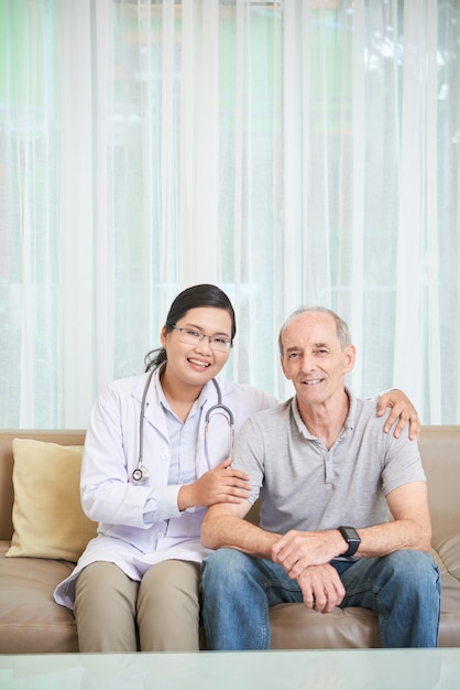 Älterer mann und doktor, die auf sofa im wohnzimmer sitzt Kostenlose Fotos