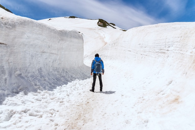 Alleinmann, der auf schneegehweg bei tateyama kurobe alpine route steht. Premium Fotos