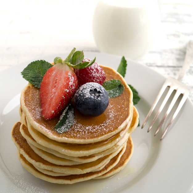 Amerikanische pfannkuchen mit beeren auf hellem hintergrund. | Premium-Foto