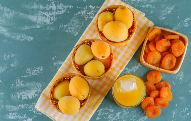 Aprikosen in körben mit getrockneten aprikosen, saft flach auf gips und ...