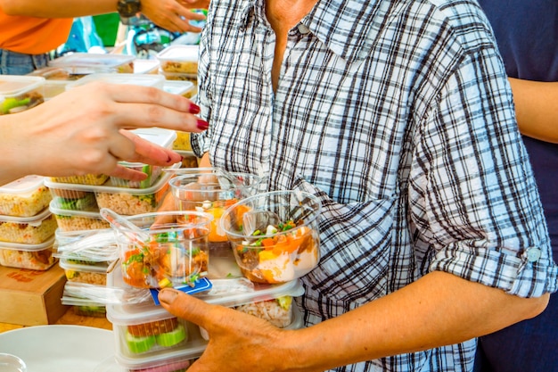 Arme leute, die essen von freiwilligen erhalten PremiumFoto