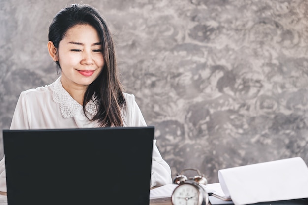 Asiatische geschäftsfrau glücklich am computer arbeiten Premium Fotos