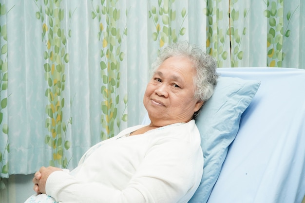 Asiatischer älterer oder älterer frauenpatient alter dame, der auf bett sitzt Premium Fotos