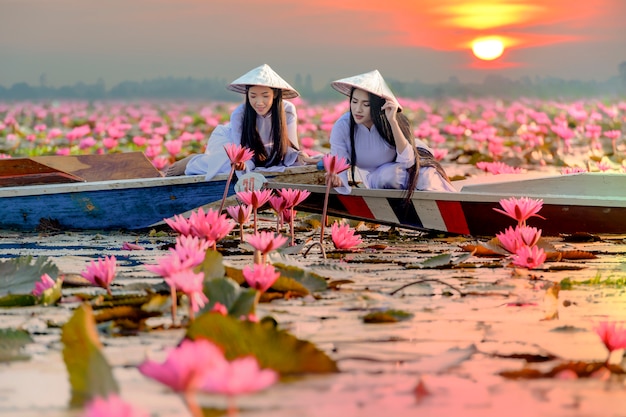 Asiatisches Madchen Im Nationalen Kostum Von Vietnam Sitzend Auf Dem Boot Im Meer Des Roten Lotos In Undon Thani Thailand Premium Foto