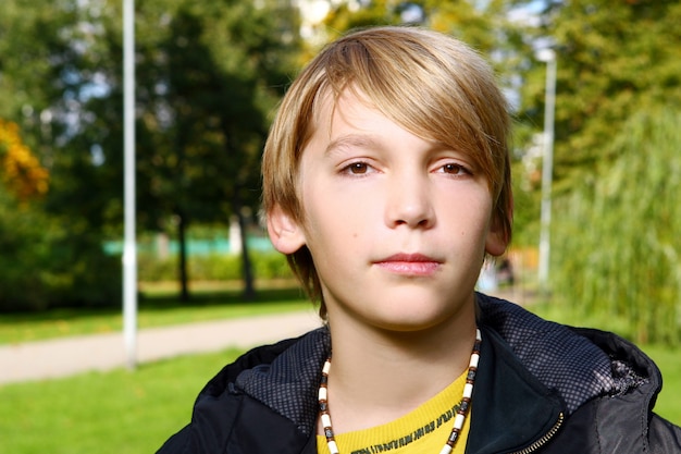 Attraktiver blonder junge, der im park aufwirft Kostenlose Fotos