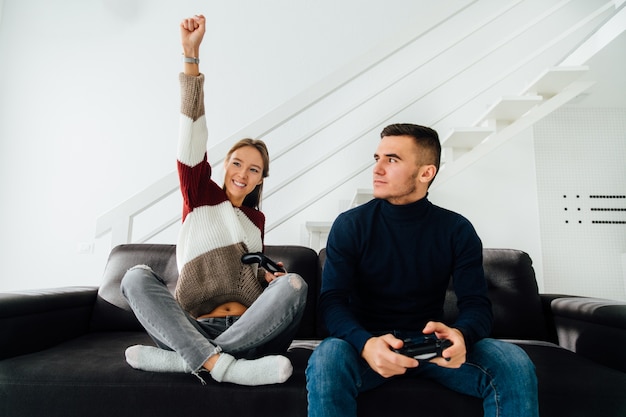 Aufgeregtes nettes mädchen feiern das gewinnen, hoben ihre faust oben an, nachdem sie computerspiele gespielt haben Kostenlose Fotos