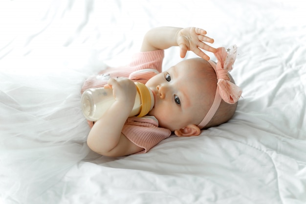 Baby Trinkt Milch Von Einer Flasche Auf Einem Weissen Bett Kostenlose Foto