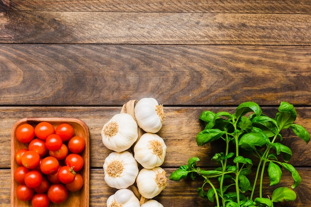 Basilikum in der nähe von knoblauch und tomaten | Kostenlose Foto