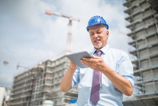 Baustellenleiter Der Sein Tablet Vor Einer Baustelle Verwendet Premium Foto